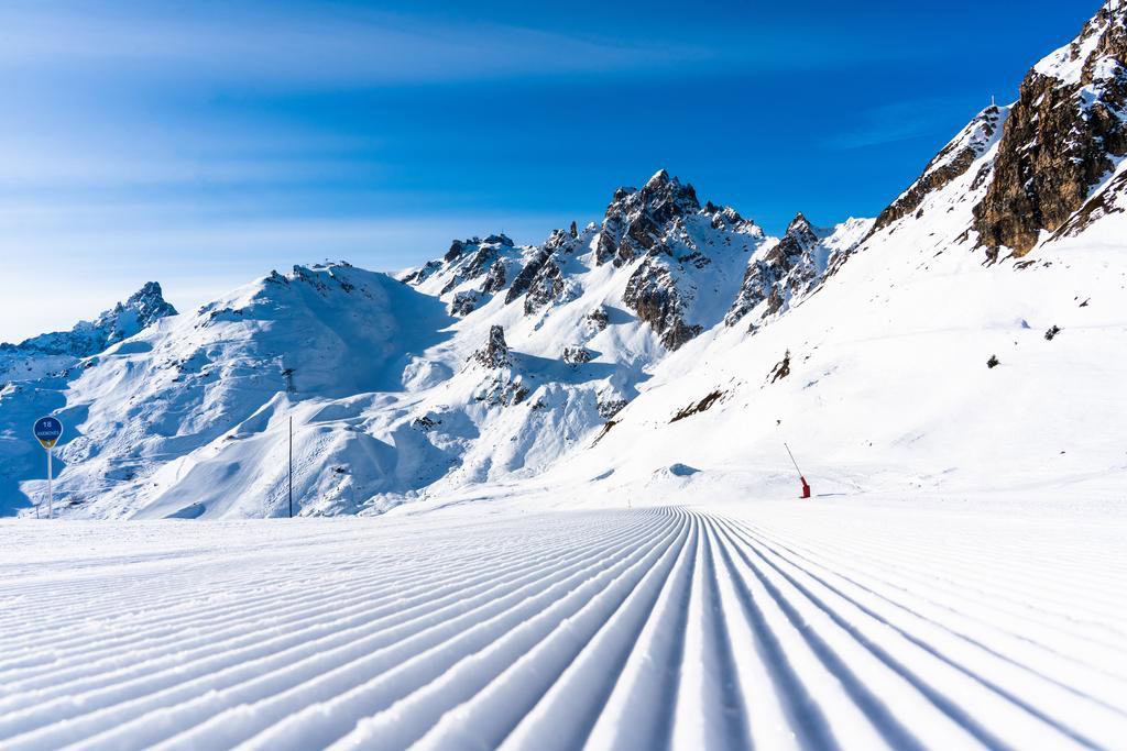 Vivid snow-covered mountain landscape with clear blue sky in Les Menuires, ideal for skiing holidays.